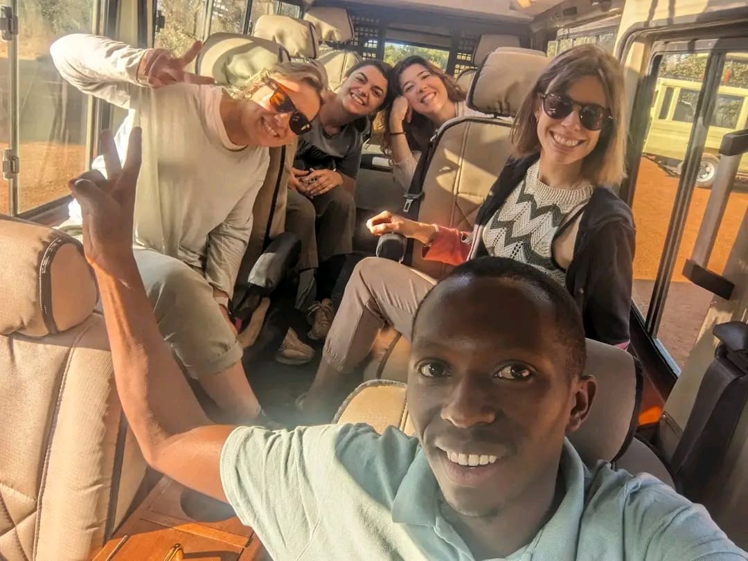 Travellers and their guide in a safari vehicle on the way to Akagera National Park